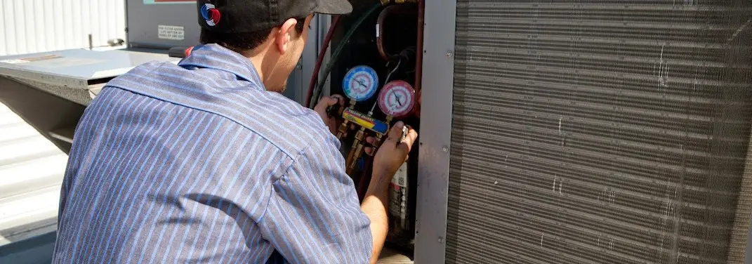 HVAC technician servicing a condenser unit in Orange City