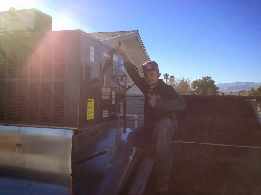 HVAC technician performing Boiler Repair on a rooftop unit in Orange City